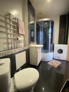 a bathroom with a toilet and a sink and a shower at Таунхаус 99 in Petropavlovskaya Borshchagovka