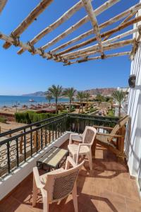 a balcony with chairs and a view of the beach at Panda resort in Dahab