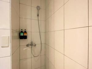 a bathroom with a shower with two bottles of alcohol at Small Island Homestay in Tainan