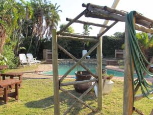 um jardim com uma rede de descanso e uma piscina em Blue Horizon Bay Guest House em Van Stadensriviermond