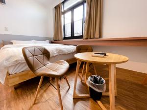 台南的住宿－小島民宿，卧室配有1张床、1张桌子和1把椅子