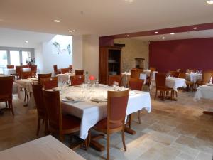 a dining room with white tables and chairs at Logis- Hôtel Spa Restaurant l'Epicurial in Saint-Pey-de-Castets