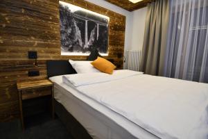 a bedroom with a large white bed with a wooden wall at Elite in Zermatt