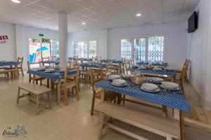 comedor con mesas azules y sillas de madera en Albergue Multiaventura Active Andalucia, en Almodóvar del Río