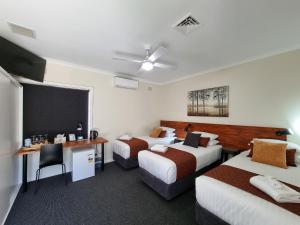 a hotel room with two beds and a chalkboard at Black Sheep Motel Goulburn in Goulburn