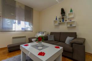 uma sala de estar com um sofá e uma mesa em Predo Apart em Zlatibor