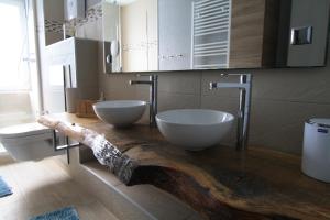 un bagno con due lavandini su un bancone in legno di harz-traum.2 a Gernrode - Harz