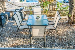 a group of chairs and a table with a plant on it at Beach Apartments in Tivat