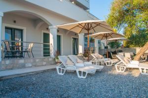 a group of chairs and umbrellas on a patio at Beach Apartments in Tivat