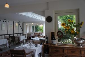 a dining room with tables and chairs and a window at Lyng Dal Hotel og Restaurant in Ry