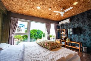 a bedroom with a large bed and a window at Mahalo B&B in Magong