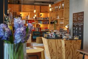 a coffee shop with a counter with flowers on it at elferrooms Hotel in Ubstadt-Weiher