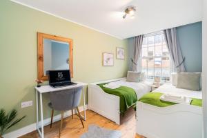 1 dormitorio con 2 camas y escritorio con ordenador portátil en Central Apartment With 55” Smart TV+Netflix en Andover