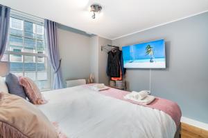 a bedroom with a large bed with a tv on the wall at Central Apartment With 55” Smart TV+Netflix in Andover