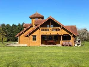 Una gran casa de madera con una torre en la cima de un campo en Norman XXL Cottage 3 stars 15' drive to the beach and perfect to seminaries, en Sauqueville