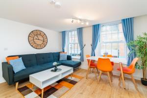 a living room with a couch and a table at Central Apartment With 55” Smart TV+Netflix in Andover