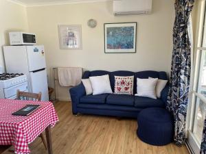 a living room with a blue couch and a table at Amazing Views Pet Friendly Bed and Breakfast in Yass