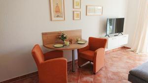 uma mesa de jantar com 2 cadeiras e uma televisão em Godewind em Insel Poel