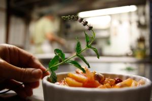 uma pessoa está segurando uma planta em uma tigela de comida em La Locanda Cuccuini em Cavriglia