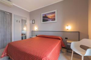 a bedroom with a red bed and a table and chair at Affittacamere Giannina in Alassio