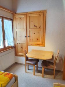 a room with a wooden table and chairs and a bed at Chalet Alba A in Bürchen