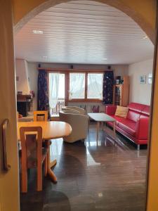 uma sala de estar com um sofá vermelho e uma mesa em Chalet Alba A em Bürchen