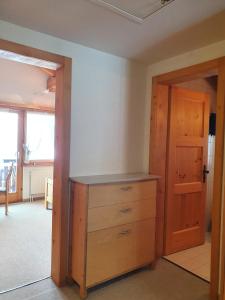 a room with a wooden dresser and a door at Chalet Alba A in Bürchen