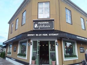 a building with a sign that reads pizza kitchen at Mysig takvåning med balkong in Eskilstuna