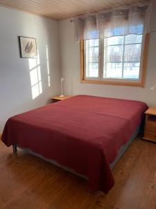 1 dormitorio con 1 cama grande con colcha roja en Levi Kaakkuri 6 en Levi