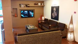 a living room with a couch and a tv at Smart Hotel in Seremban