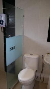 Baño pequeño con aseo y lavamanos en Smart Hotel, en Seremban