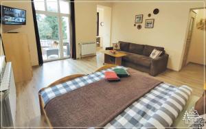 a living room with a bed and a couch at Przystanek Rabka - Apartamenty w centrum in Rabka-Zdrój