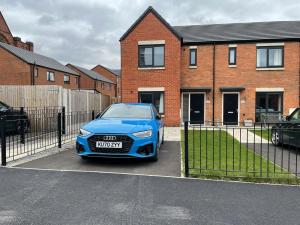 a blue car parked in front of a house at Modern Room With Huge Bed - Walk to City Centre! in Manchester