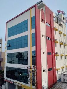 a building with a red and white at Hotel Mookambika Comforts in Tirupati