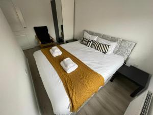 a bedroom with a large bed with white sheets and pillows at Modern Room With Huge Bed - Walk to City Centre! in Manchester