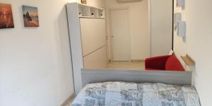 a small bedroom with a bed and a red chair at Residence Eurotel da Nella e Stefano in Rapallo +16 photos