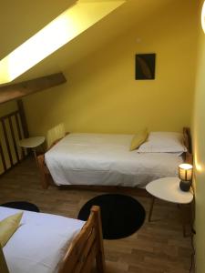 ein Hotelzimmer mit 2 Betten und einem Tisch in der Unterkunft Le Gîte du Tau in Touquin