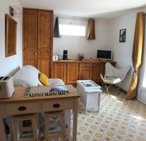 a living room with a table and a kitchen at Studio L’ARGENTIERE PLAGE in La Londe-les-Maures