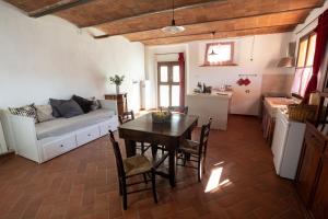een woonkamer met een tafel en een bank bij Agriturismo Colle Vento in Suvereto