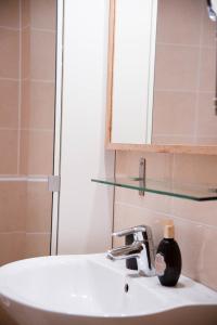 - un lavabo avec miroir et une bouteille de savon dans l'établissement Apartment Tereza, à Prague