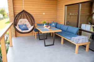 a patio with a swing and a table and chairs at Шале Рутенія - Chalet Rutenia apartments in Neporotovo