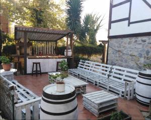 a patio with white benches and a gazebo at Casa Roiz in Santillana del Mar