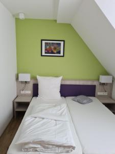 1 dormitorio con 2 camas y pared verde en Hotel Gasthof zum Engel, en Künzelsau