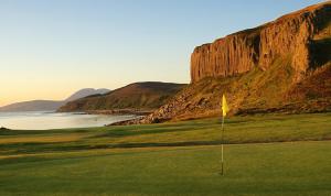 a golf course with a mountain in the background at Kinloch Hotel, Isle of Arran in Blackwaterfoot