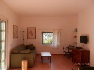 a living room with a couch and a tv at Dèpendance Argentario in Porto Santo Stefano