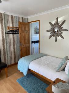 een slaapkamer met een bed en een klok aan de muur bij The Peels B&B in Lowestoft