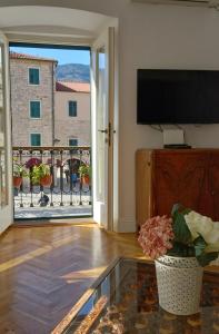 sala de estar con TV y mesa de cristal en Old Town Sea Gate Apartment, en Kotor
