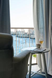 una mesa con una copa de vino y una silla en La Baia di Ortigia, en Siracusa