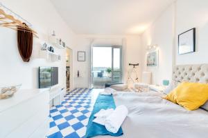 a white room with a bed and a blue and white floor at La Baia di Ortigia in Syracuse