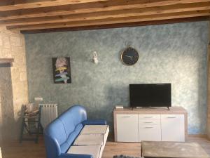 a living room with a blue couch and a tv at Apartamento S-XVIII la RANITA SALMANTINA in Salamanca